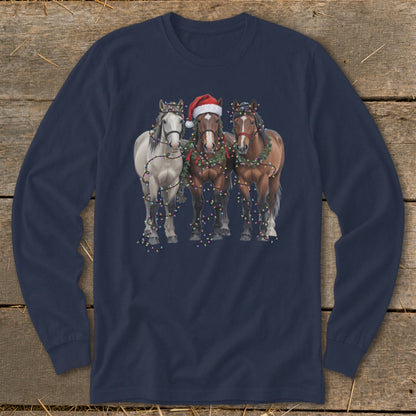 Three horses wearing Christmas lights and one a Santa hat.