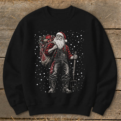 Santa Claus wearing overalls and plaid shirt, carrying a sack of gifts and a pitchfork.