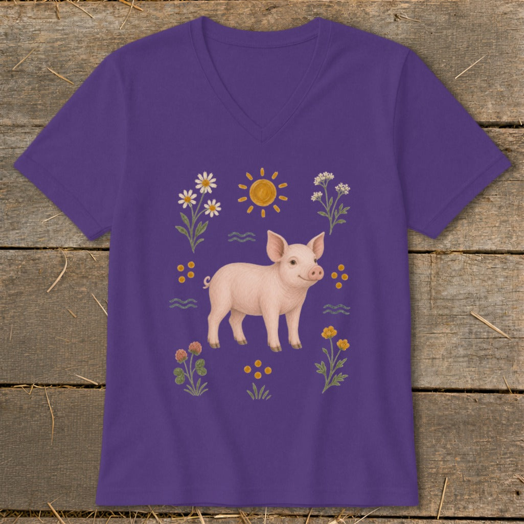 Purple t-shirt with a pink piglet surrounded by flowers, sun, and wavy lines.