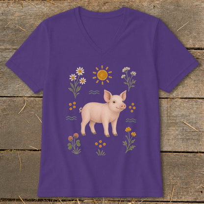 Purple t-shirt with a pink piglet surrounded by flowers, sun, and wavy lines.