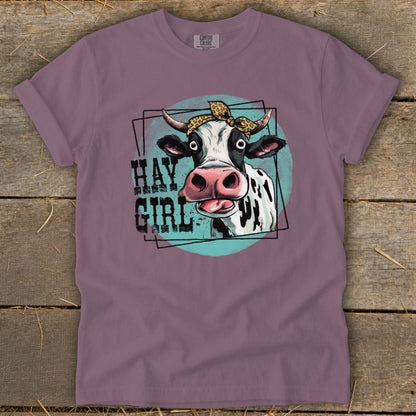 Cow graphic with "HAY GIRL" text on a purple t-shirt.