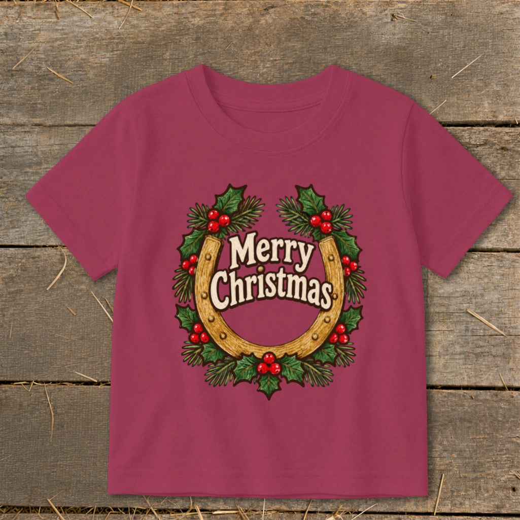 Pink t-shirt with a Christmas wreath around a horseshoe and "Merry Christmas" text.