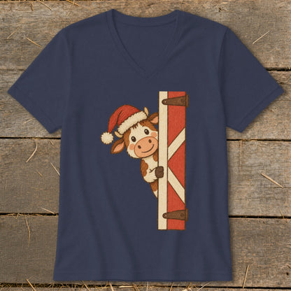 Cartoon cow wearing a Santa hat peeking around a red barn door.