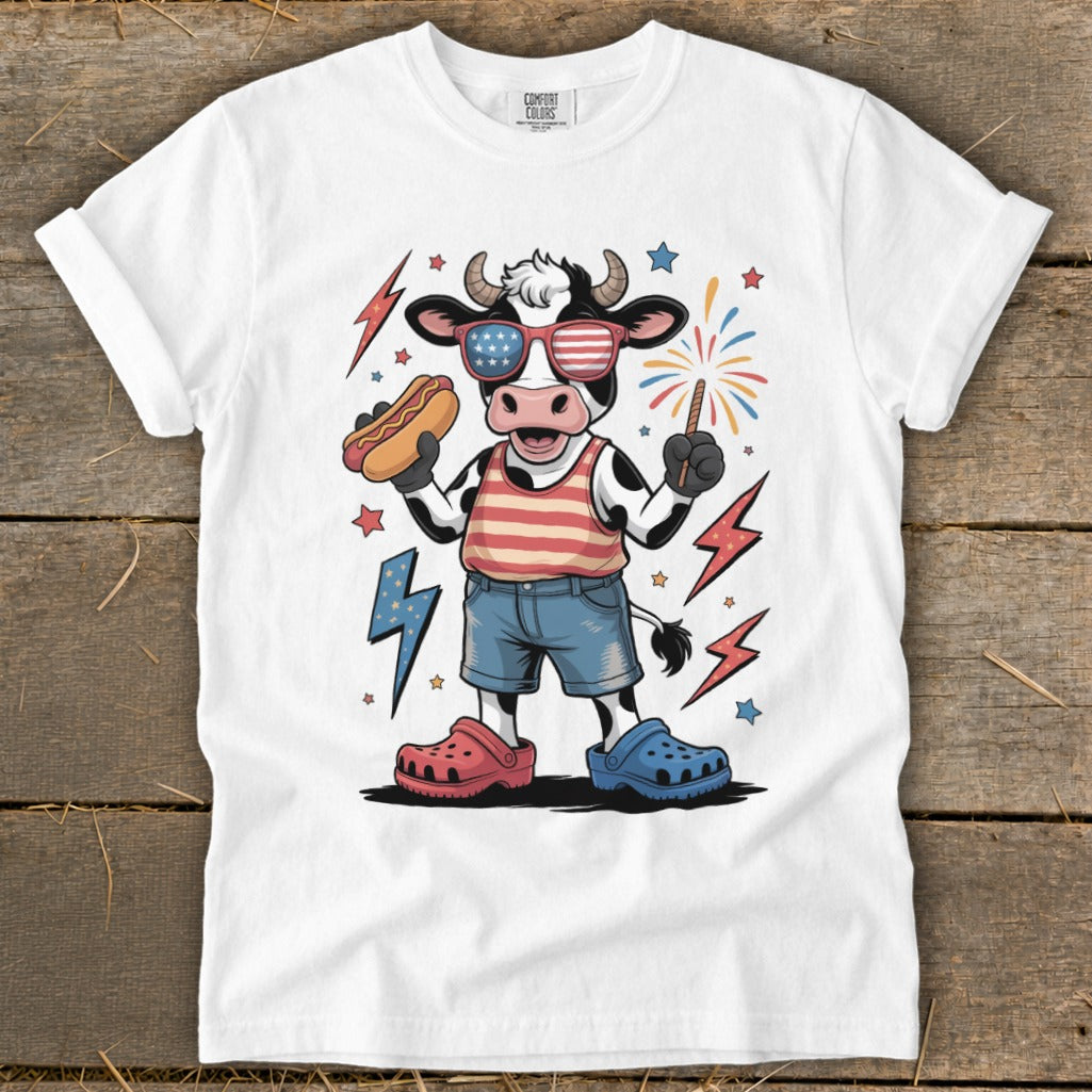 Cow wearing American flag sunglasses and holding a hot dog.