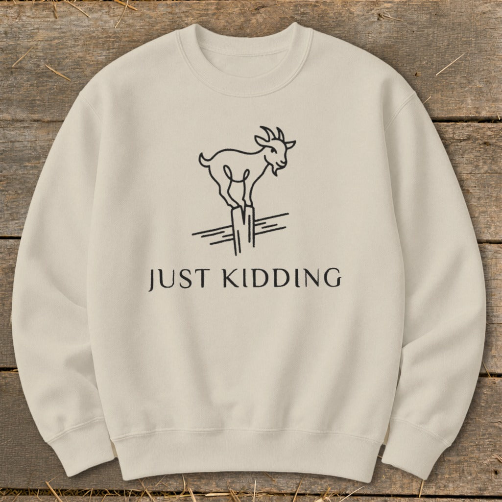 Light cream sweatshirt with a black line drawing of a goat on a fence post and text.