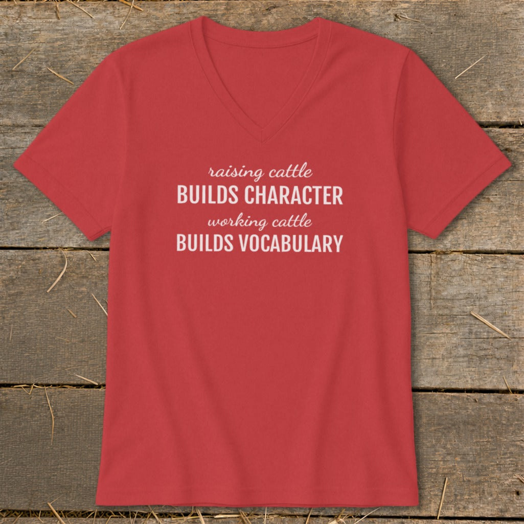 Red v-neck t-shirt with white text: "raising cattle BUILDS CHARACTER working cattle BUILDS VOCABULARY".
