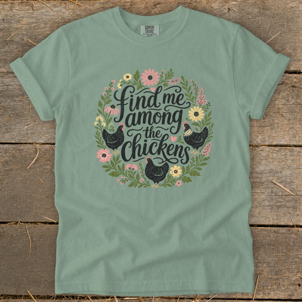 Green t-shirt with "Find me among the chickens" text and chicken graphics.