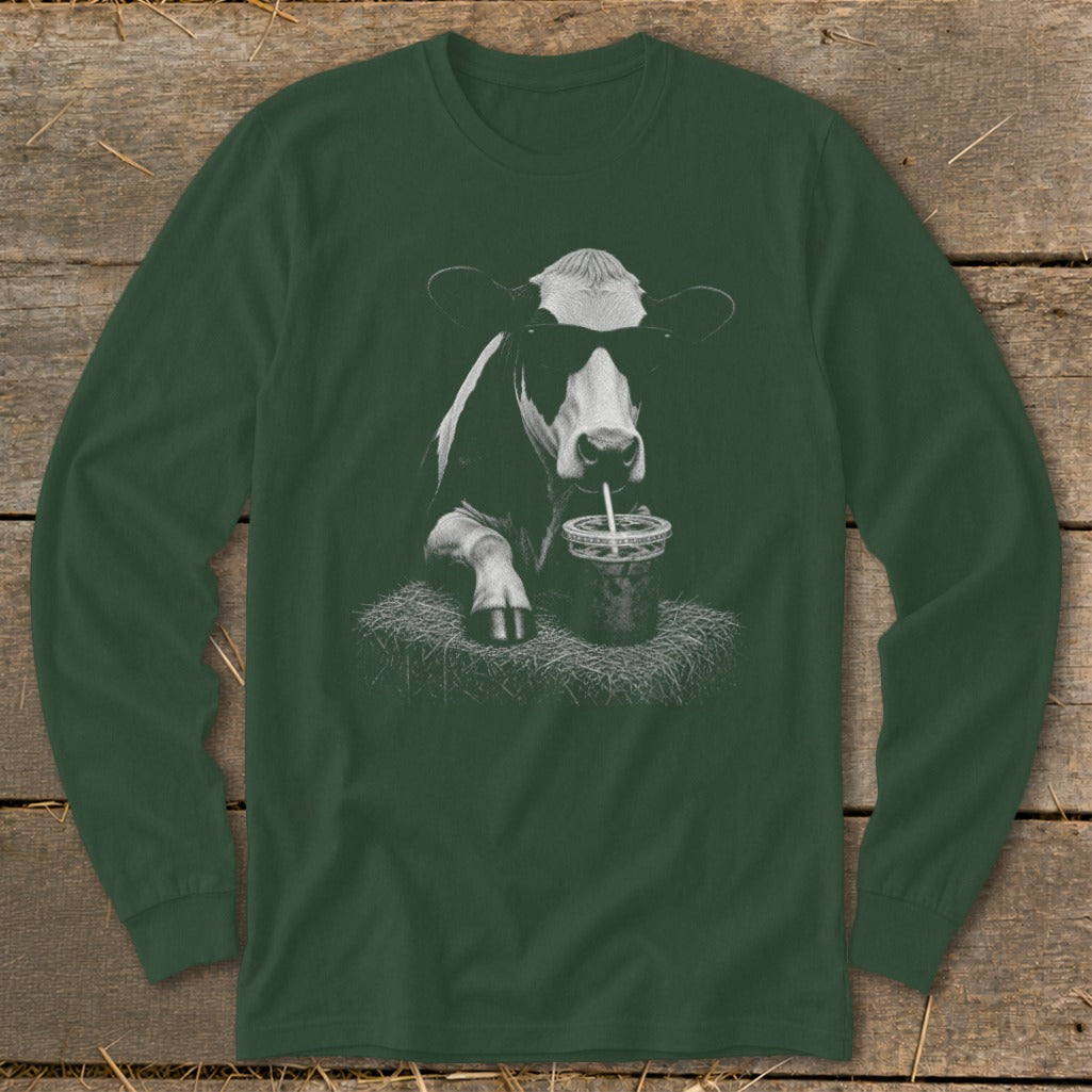 Cow with sunglasses drinking a beverage through a straw, depicted on a long-sleeved shirt.