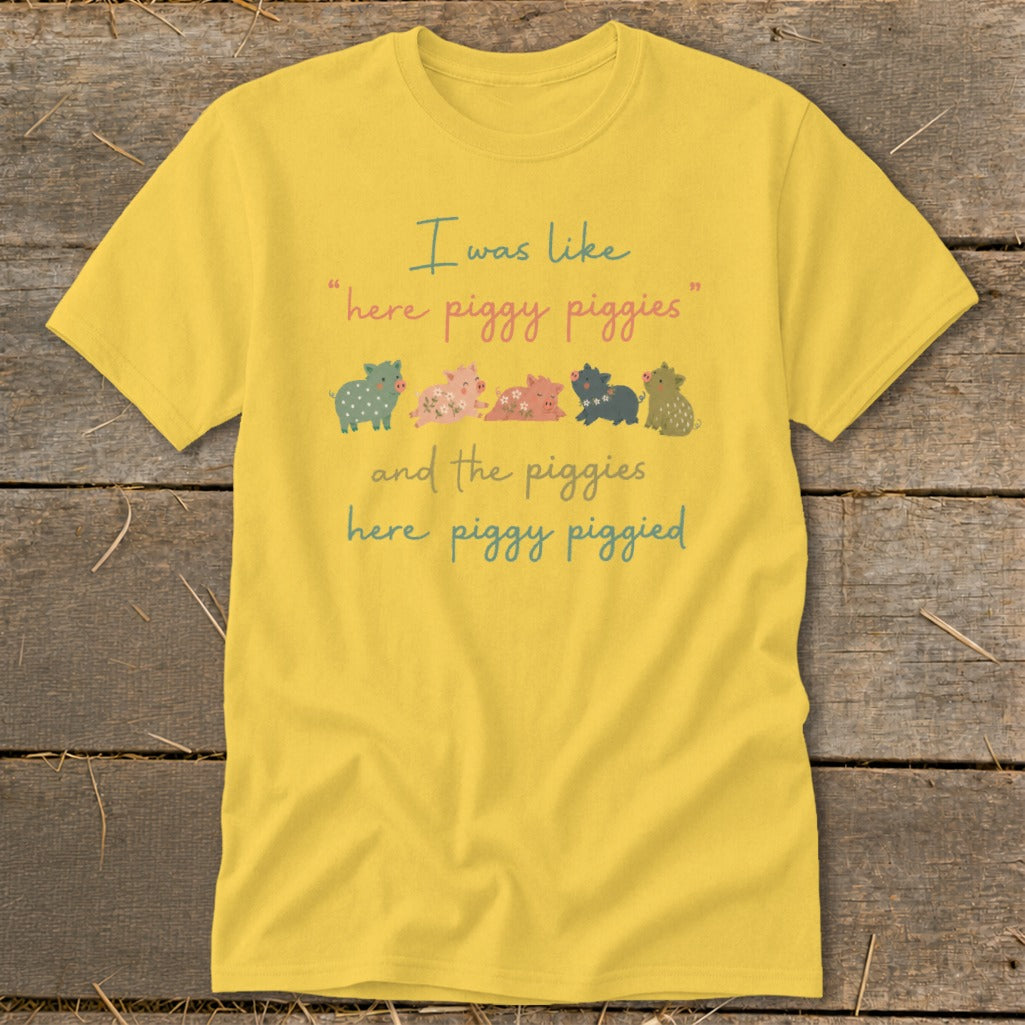 Yellow t-shirt with illustration of pigs and text "I was like 'here piggy piggies' and the piggies here piggy piggied".