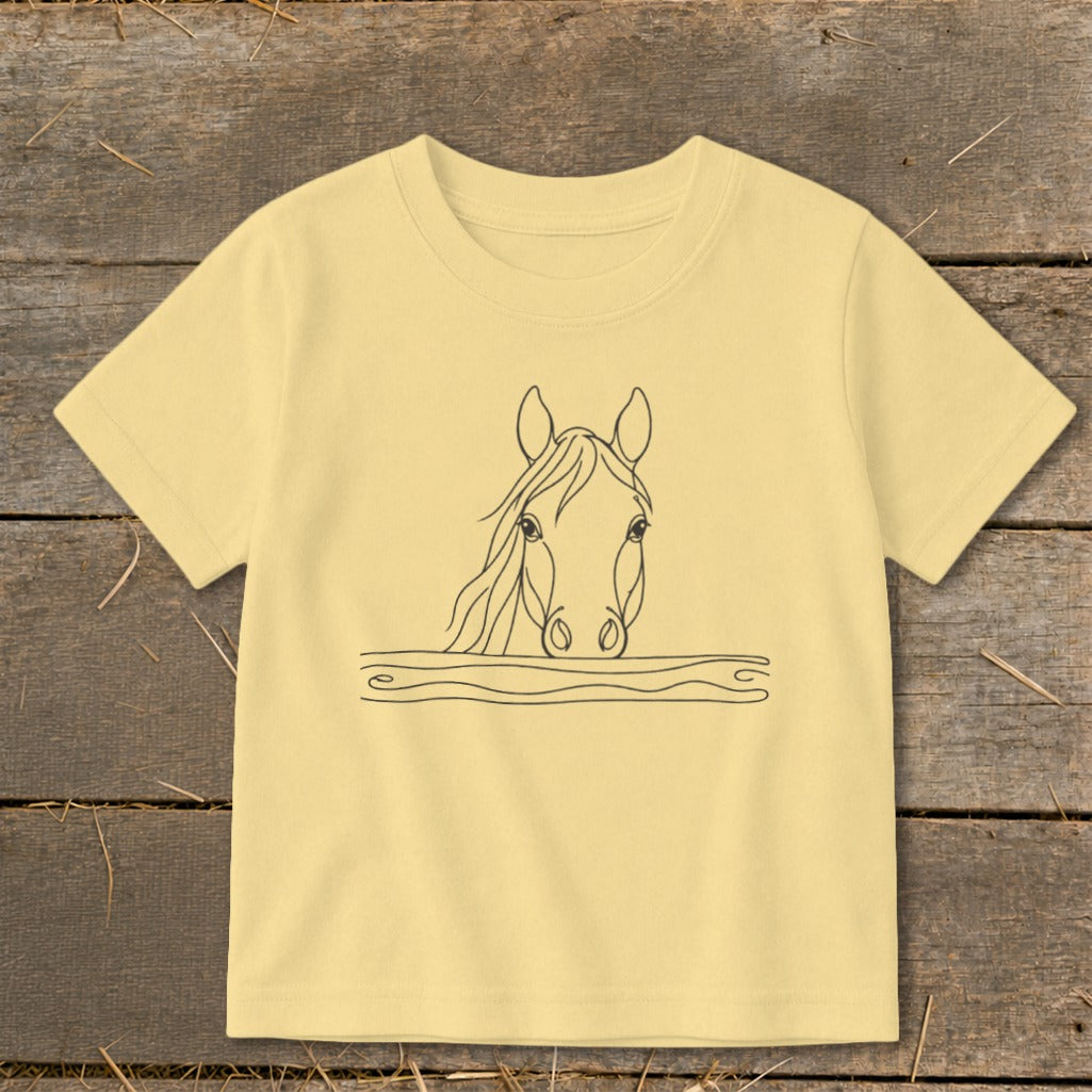 Line drawing of a horse's head emerging from wavy lines on a pale yellow t-shirt.