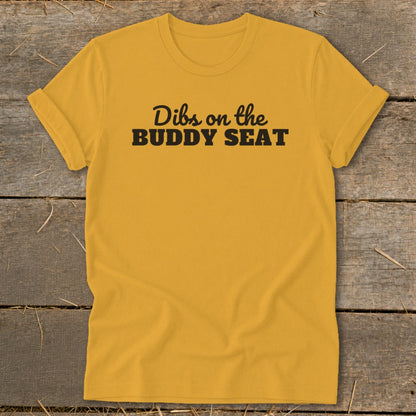Yellow t-shirt with black text reading "Dibs on the BUDDY SEAT".