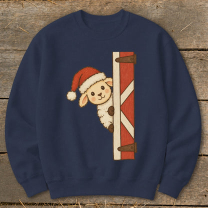 Sheep wearing Santa hat peeking from behind barn door.
