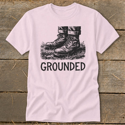 Pink t-shirt with black ink graphic of boots and the word "GROUNDED"