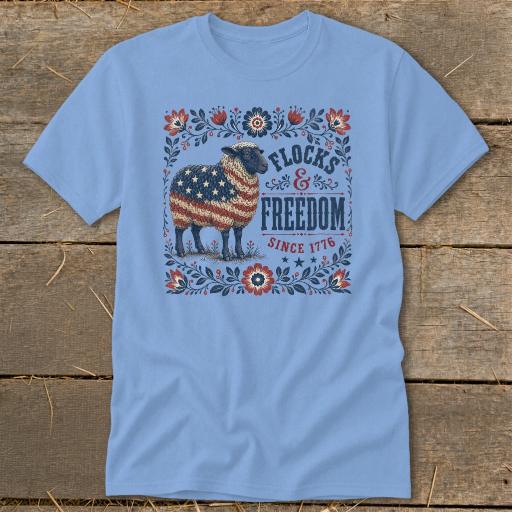 Light blue t-shirt with a patriotic sheep graphic and text "Flocks & Freedom Since 1776."