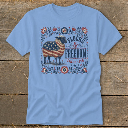 Light blue t-shirt with a patriotic sheep graphic and text "Flocks & Freedom Since 1776."