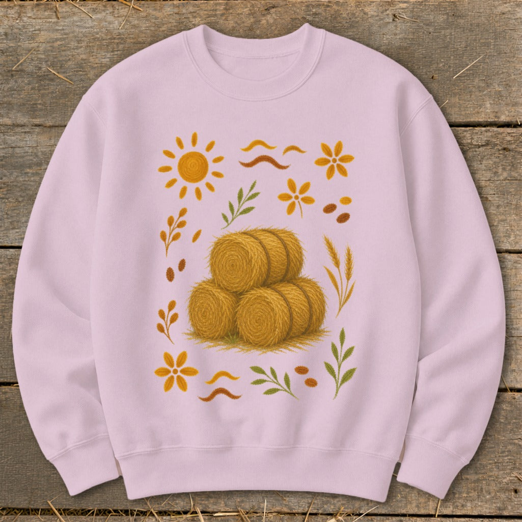 Light pink sweatshirt with a stacked hay bale design and autumnal graphics.