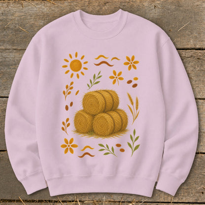 Light pink sweatshirt with a stacked hay bale design and autumnal graphics.