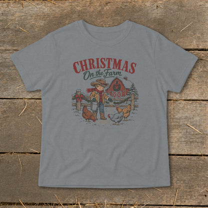 Boy feeding chickens in the snow with a barn and Christmas decorations.