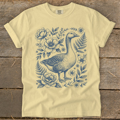 Light yellow t-shirt with a navy blue goose and floral illustration.