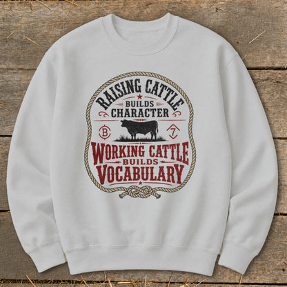 White sweatshirt with "Raising Cattle Builds Character Working Cattle Builds Vocabulary" graphic.