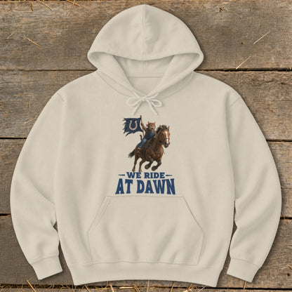 Cream hoodie with a graphic of a cat riding a horse and flag, reading "We Ride At Dawn".