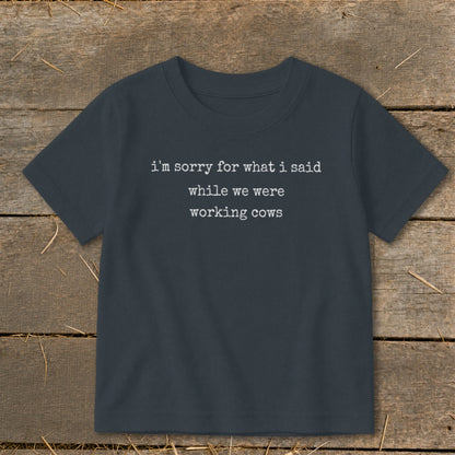 Dark gray t-shirt with white text: "i'm sorry for what i said while we were working cows."