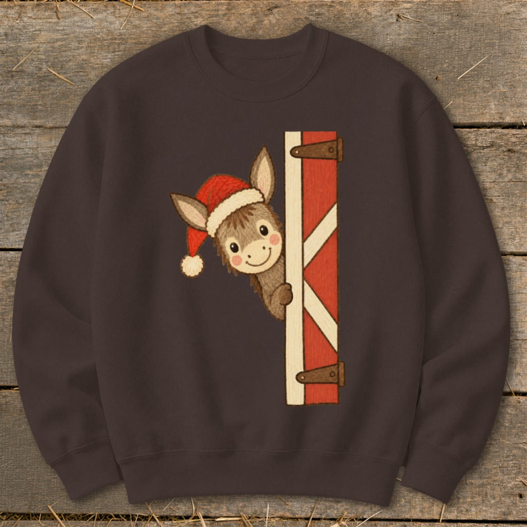 Donkey in Santa hat peeking from behind barn door graphic on brown sweatshirt.
