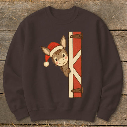 Donkey in Santa hat peeking from behind barn door graphic on brown sweatshirt.