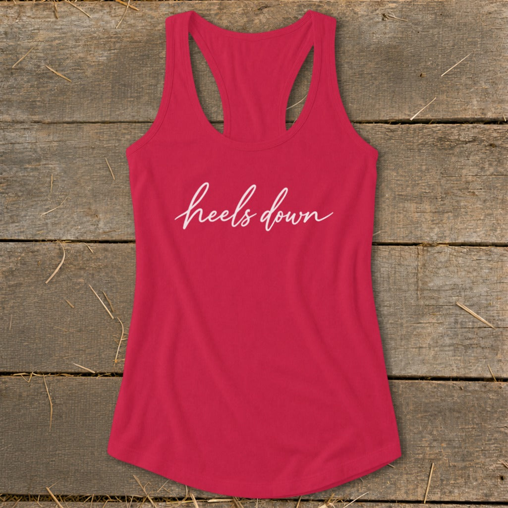 Pink racerback tank top with white cursive text "heels down".