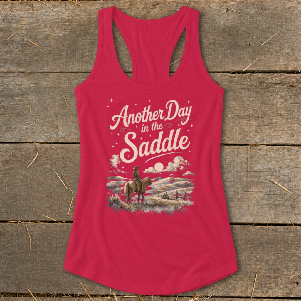 Pink tank top with "Another Day in the Saddle" graphic and cowboy on horseback.