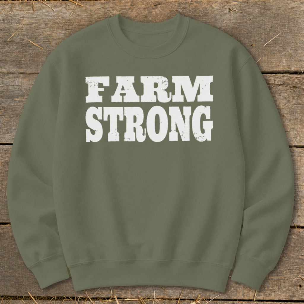 An olive green crewneck sweatshirt featuring the white distressed text "FARM STRONG" across the chest.
