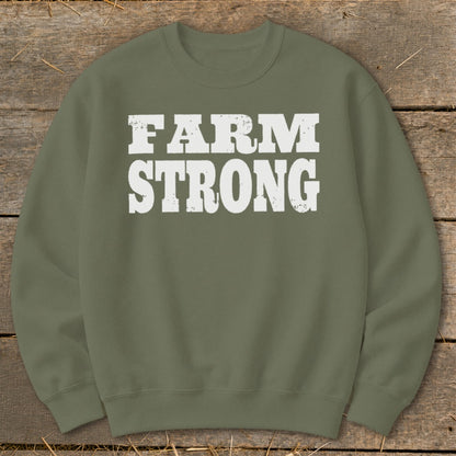 An olive green crewneck sweatshirt featuring the white distressed text "FARM STRONG" across the chest.