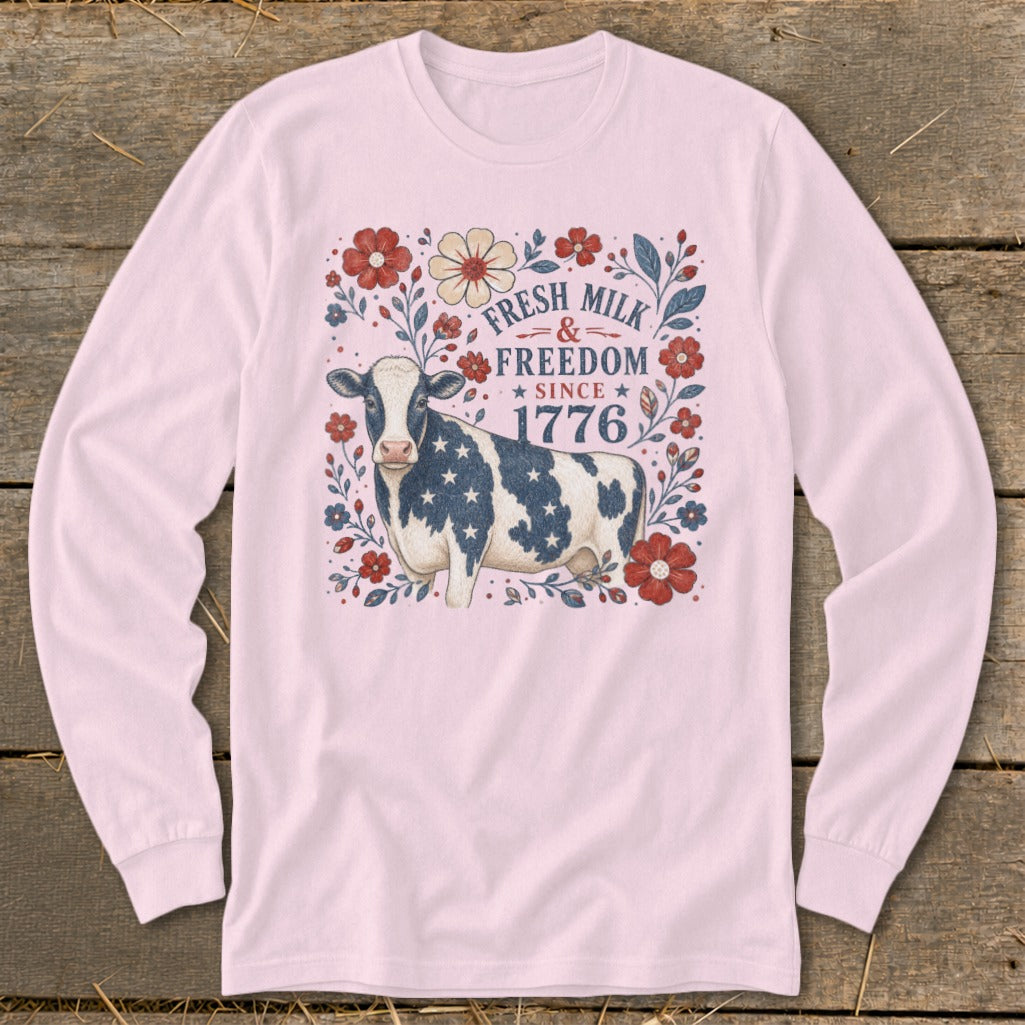Long-sleeve pink shirt with cow, flowers, and text "Fresh Milk & Freedom Since 1776."