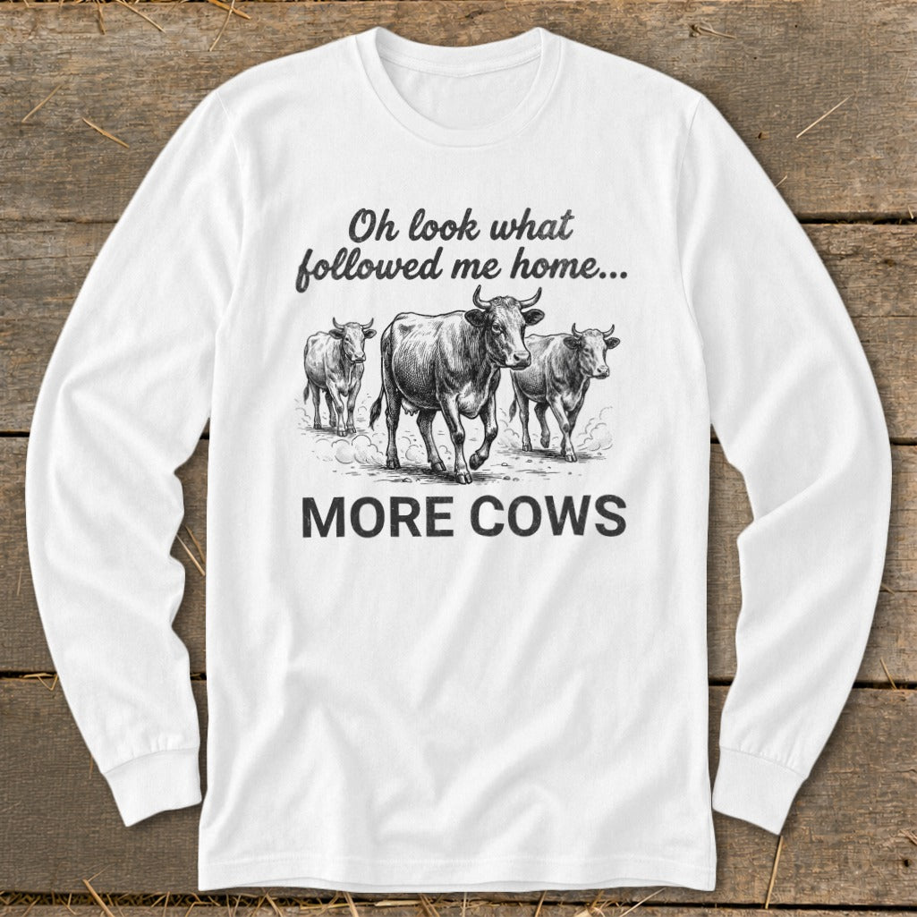 White long-sleeve shirt with cows and text "Oh look what followed me home... MORE COWS".