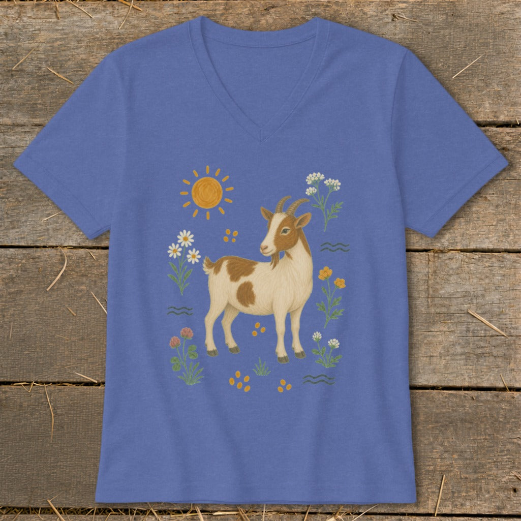 Blue t-shirt with a cartoon illustration of a brown and white goat surrounded by flowers and sun.