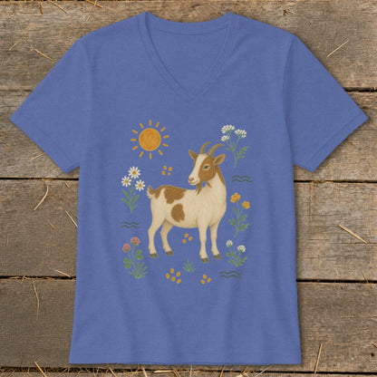 Blue t-shirt with a cartoon illustration of a brown and white goat surrounded by flowers and sun.