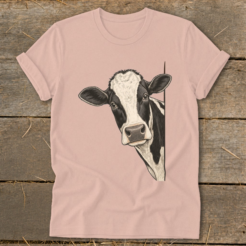 Pink t-shirt with a black and white cow peeking from the side.