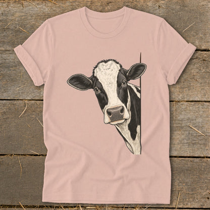 Pink t-shirt with a black and white cow peeking from the side.