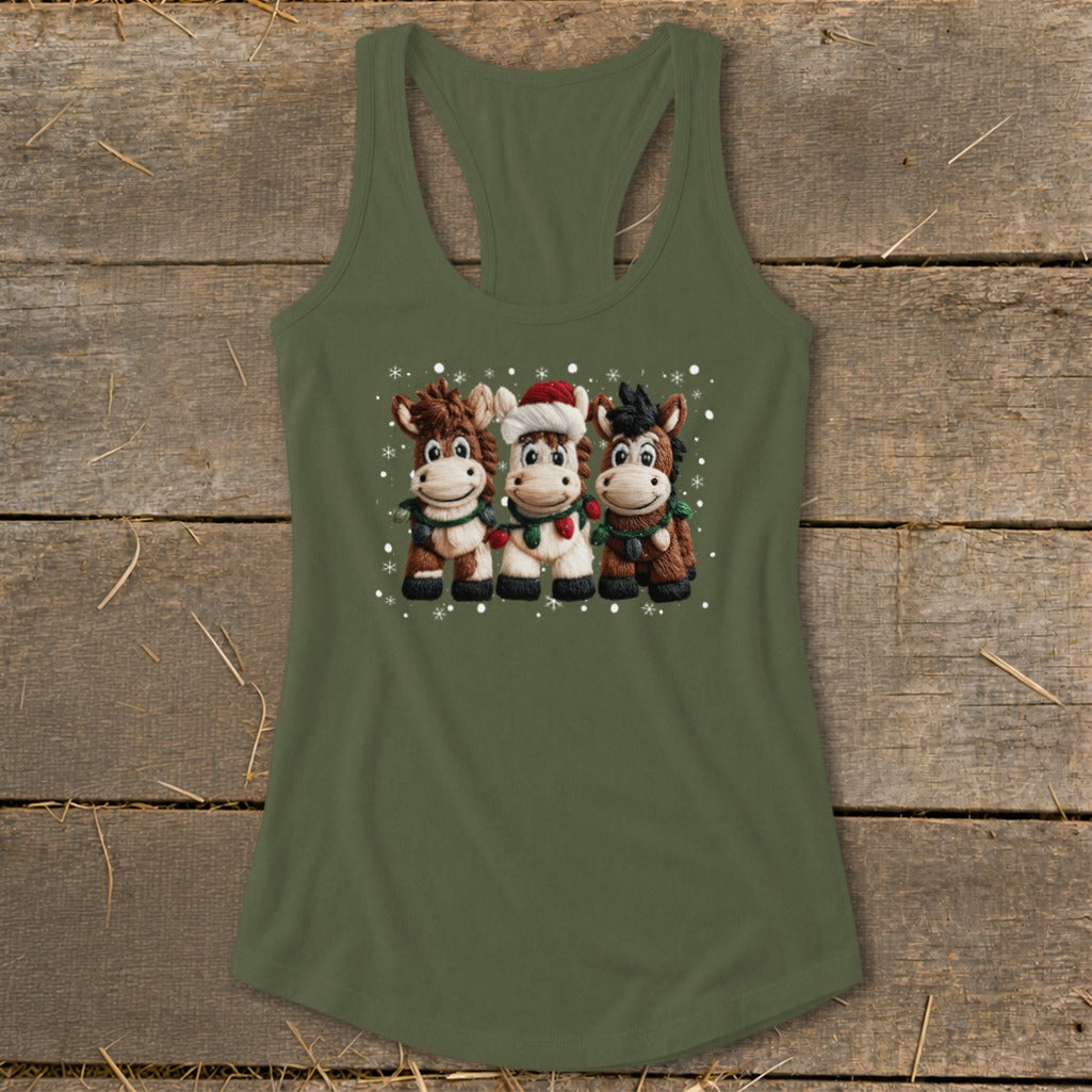 Three cartoon horses in Christmas attire with snowflakes on a green tank top.