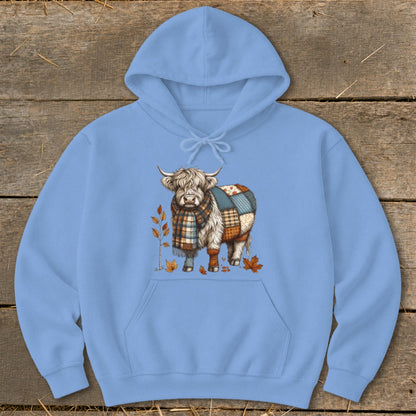 Light blue hoodie with a cartoon Highland cow wearing a scarf and patchwork body.