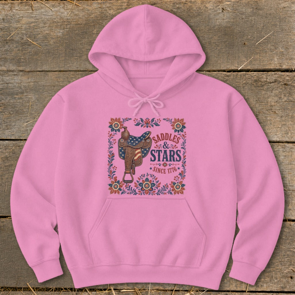 Pink hoodie with a western saddle and "Saddles & Stars Since 1776" graphic.