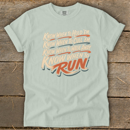 Light blue t-shirt with text: Know When To Hold 'Em, Cull 'Em, Walk Away, Run.