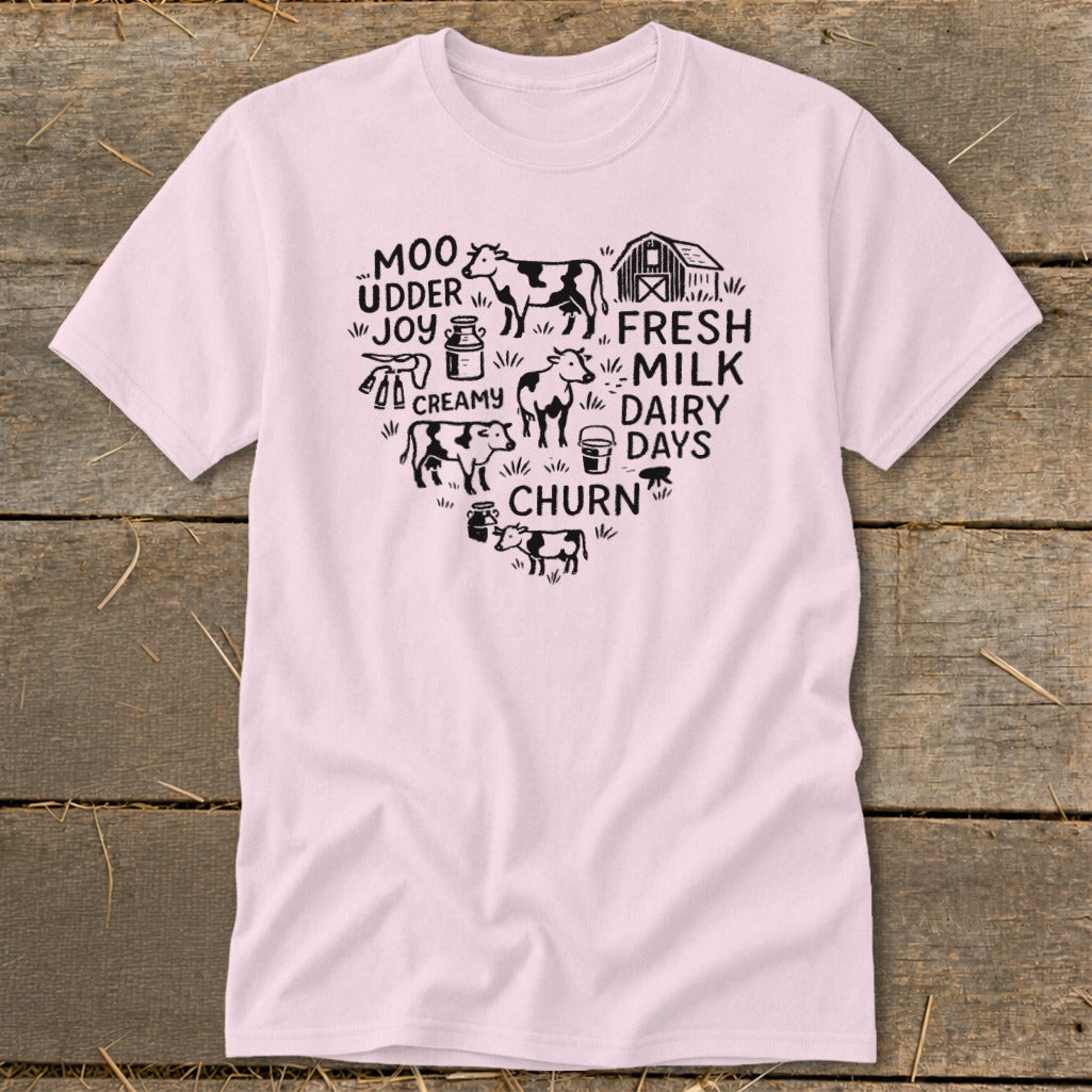 Pink t-shirt with heart-shaped farm graphic featuring cows, barn, milk cans, and text.
