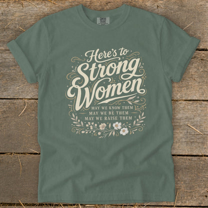 Green t-shirt with "Here's to Strong Women. May we know them, may we be them, may we raise them."