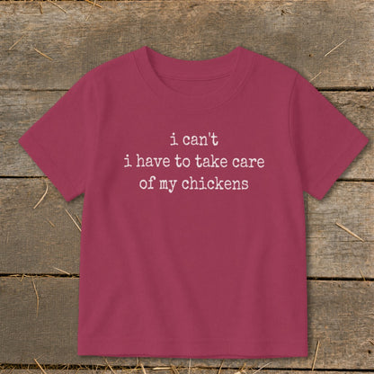 Kids' magenta t-shirt with white text saying "i can't i have to take care of my chickens".