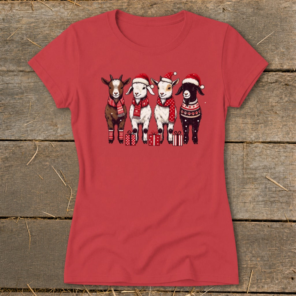Four goats in Christmas hats and scarves stand with presents.