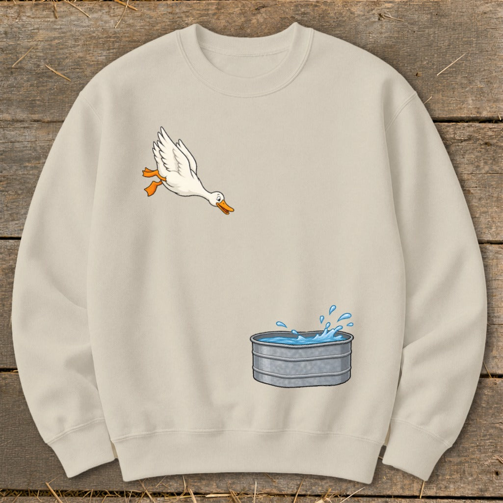 Cream sweatshirt with cartoon duck jumping into a galvanized tub of water.