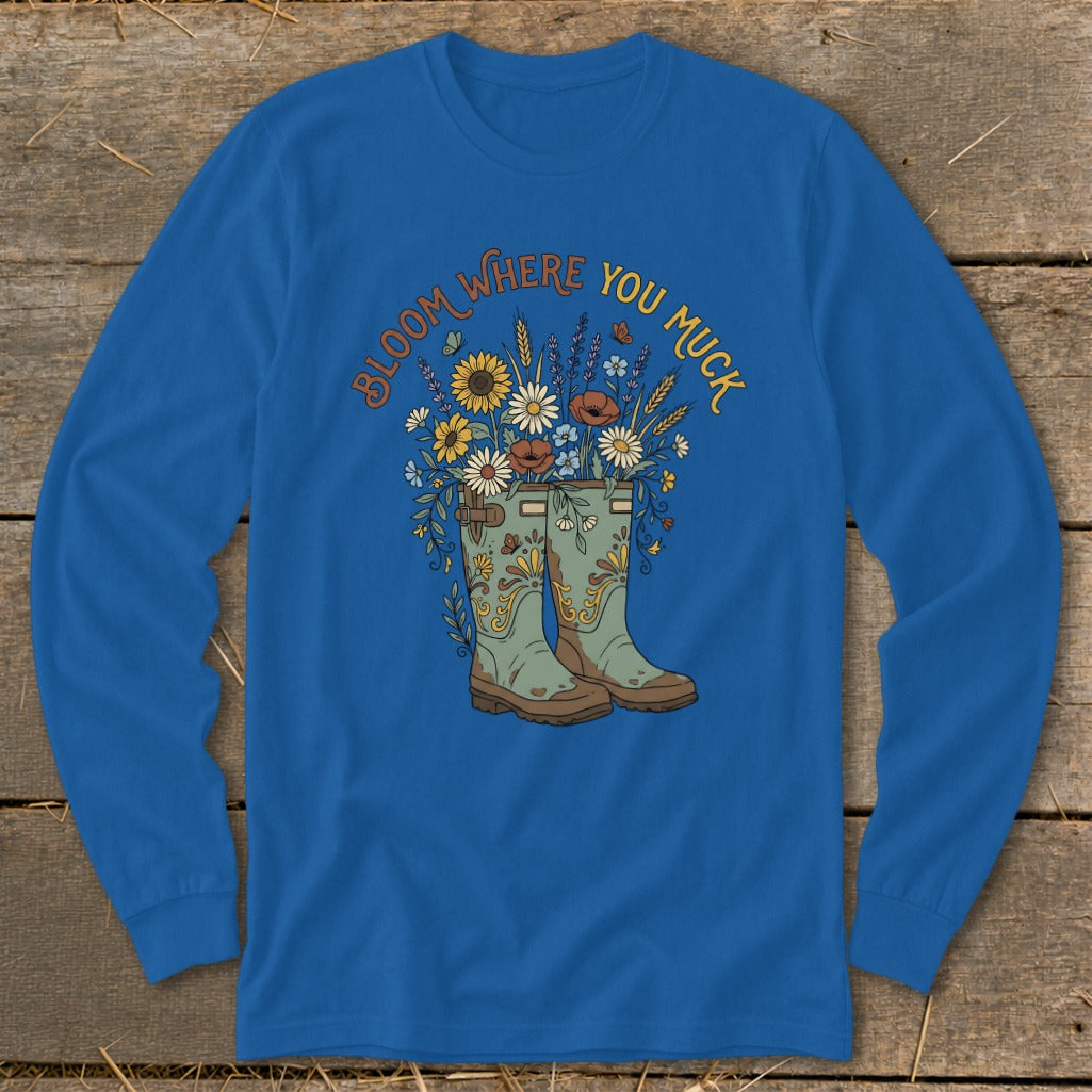 Blue long-sleeve shirt with boots and flowers graphic reading "Bloom Where You Muck."