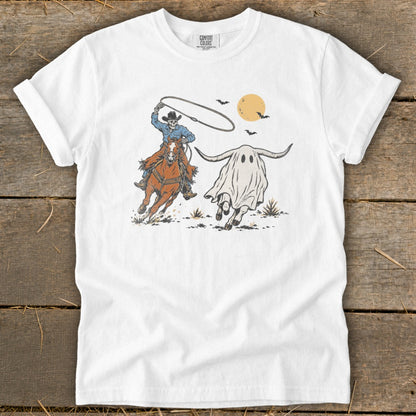 Cowboy lassos a ghost wearing longhorns on a white t-shirt.
