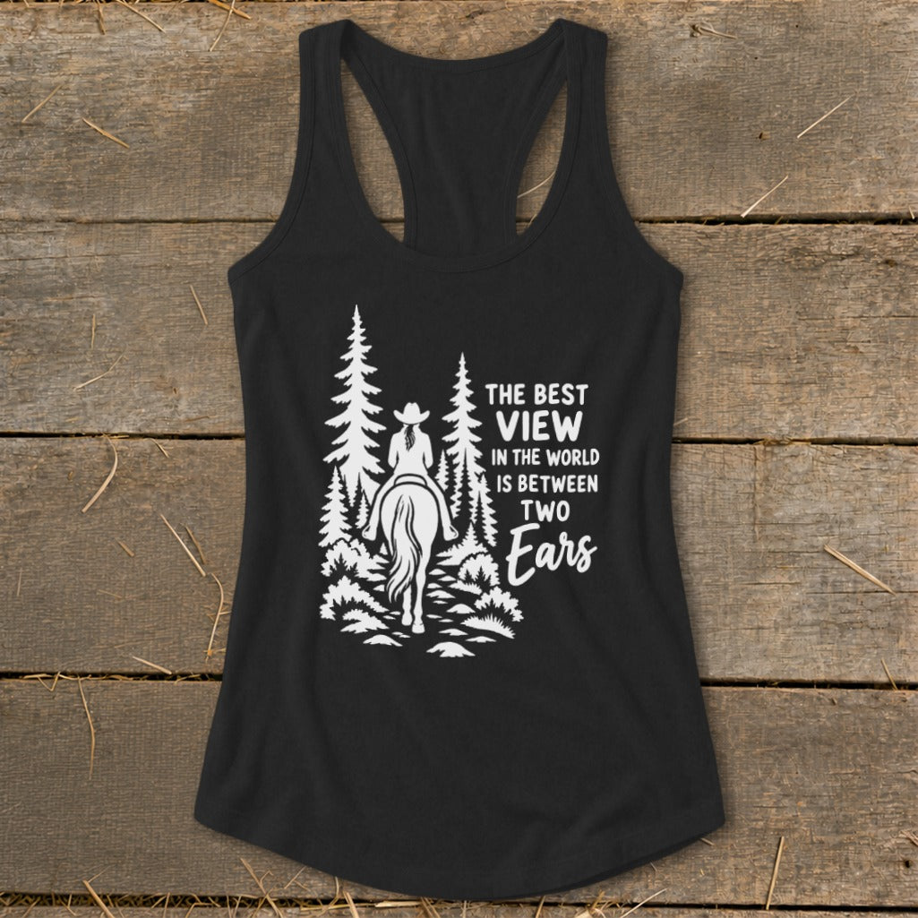 A black women's racerback tank top featuring a white graphic of a horseback rider in the woods and text that reads "The best view in the world is between two ears."